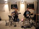 Om bandet – två röster, gitarrer och spelglädje STEP UP-duon spelar akustisk gitarr och elgitarr i en liten lokal med egen PA